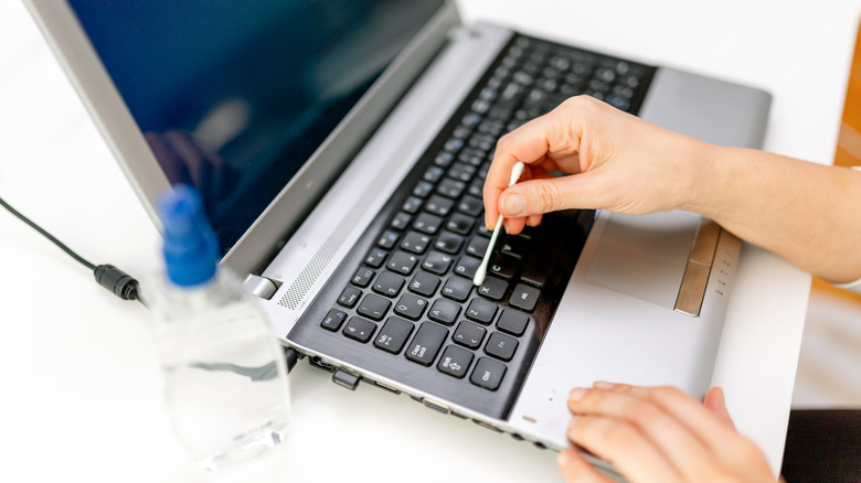 Cleaning keyboard with cotton swab