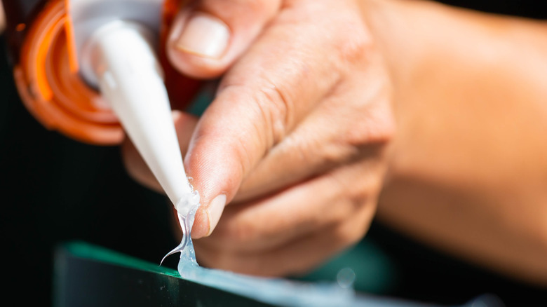 Man's hand touching super glue