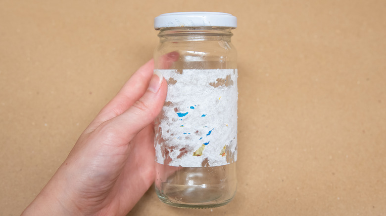 Half peeled sticker residue on glass jar