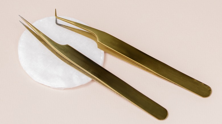 Gold tweezers on cotton