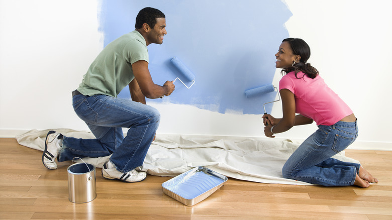 couple painting a wall blue