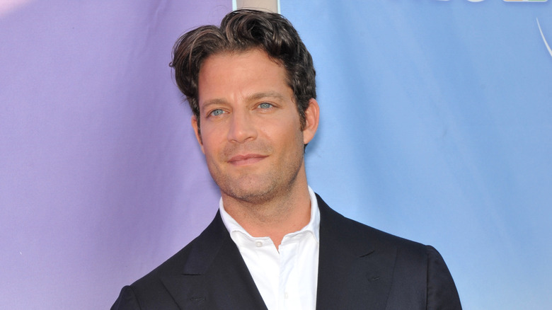 Nate Berkus posing against lavender and blue background