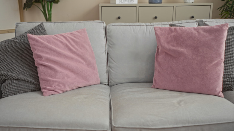 Two soft pink pillows on a gray sofa