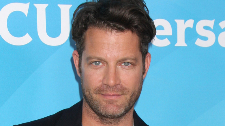 Nate Berkus posing in front of blue background