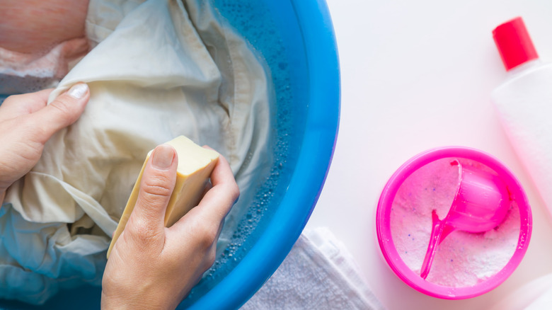 cleaning stained linens in bucket