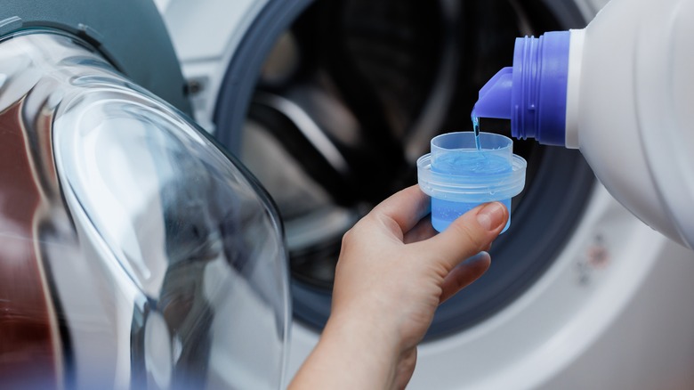 Woman putting detergent in machine