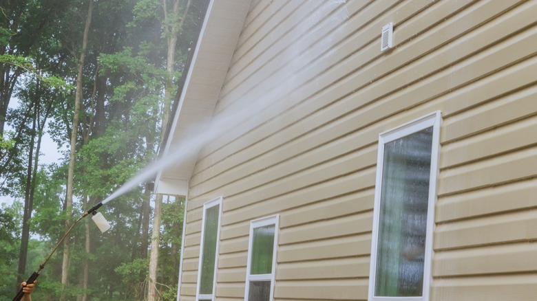 spraying the side of a house with water