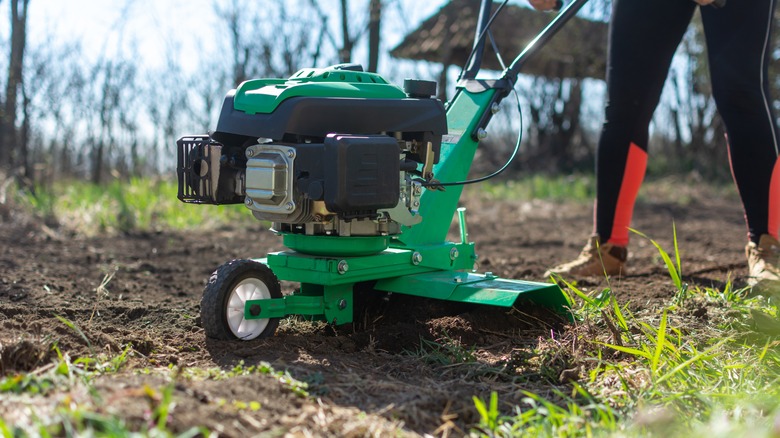 person using tilling machine 