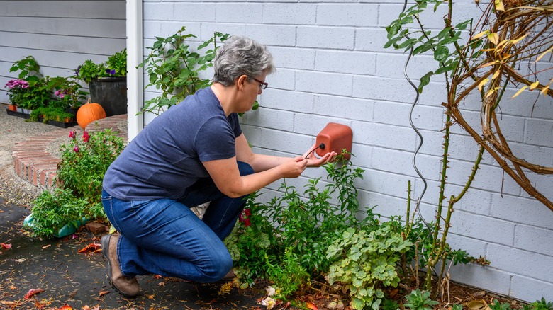 woman covering outdoor faucet