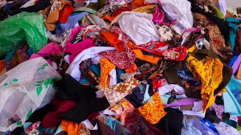 Colorful fabric scraps are piled up on the floor