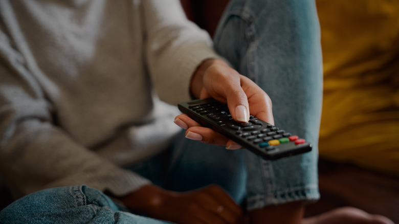 person holding TV remote