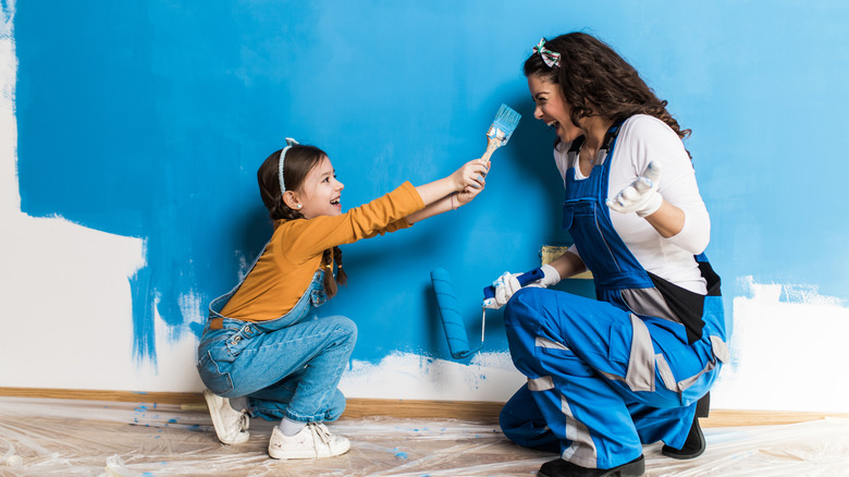 Mother and daughter painting wall