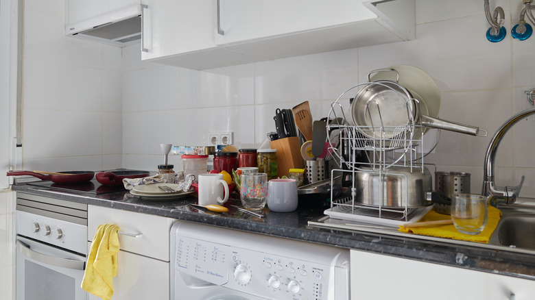 Cluttered kitchen countertop with dirty dishes