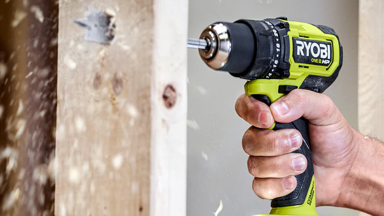 RYOBI drill being used on a plank of wood.