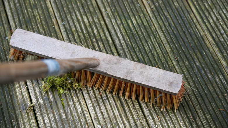 Cleaning patio with push broom