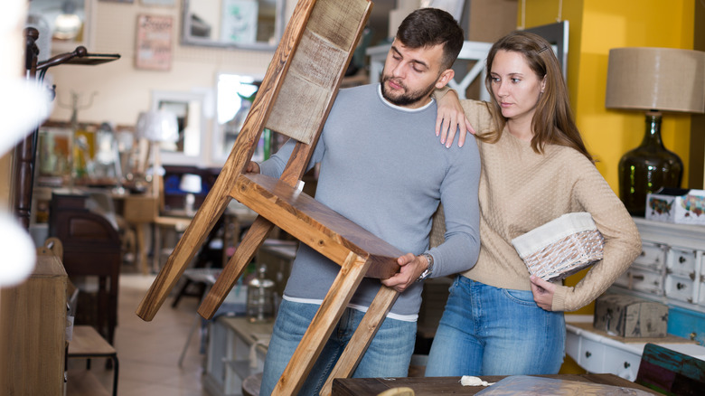 Man holding chair with woman