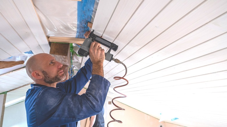 Man installing nickel gap ceiling boards