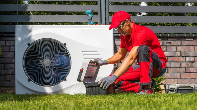 Maintenance man repairing heat pump