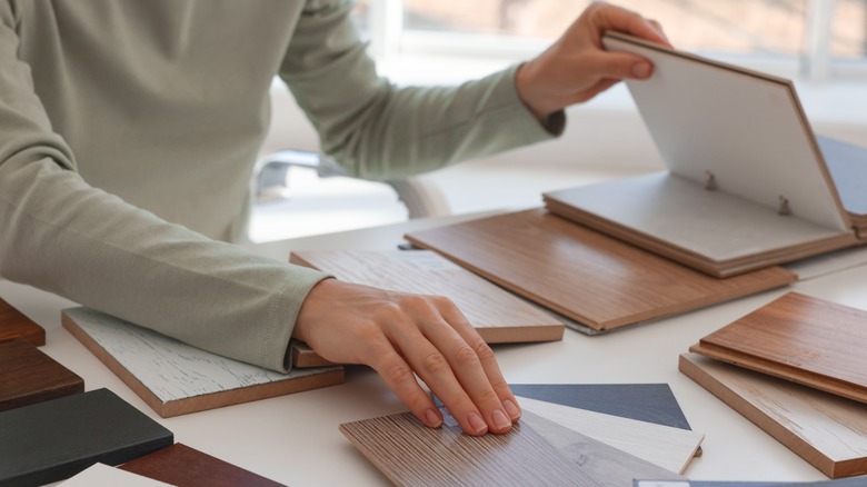 woman's hands flipping through wood samples