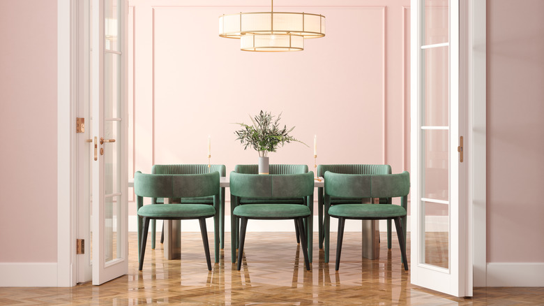 A dining room is decorated with light pink walls.