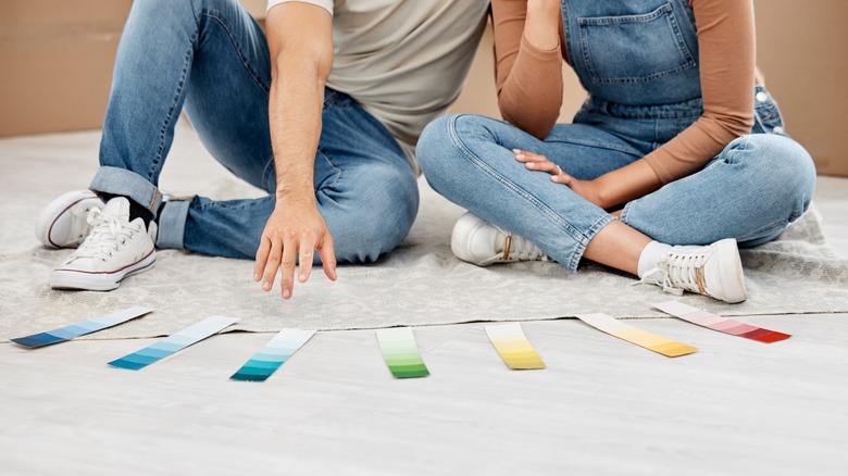 A couple looks at paint samples.