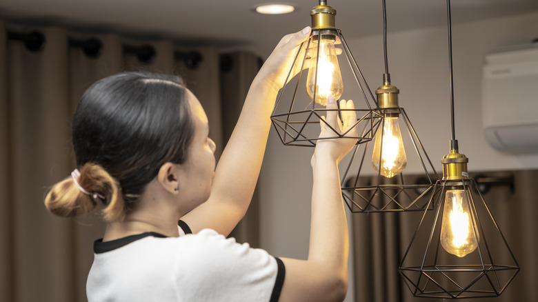 woman installing lightbulb in fixture