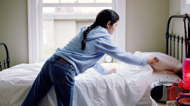 person stripping bed in a hurry