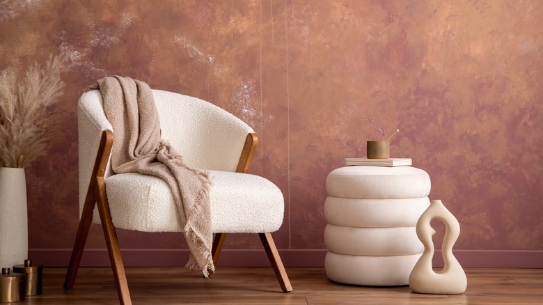 Reddish gold wall and cream chair