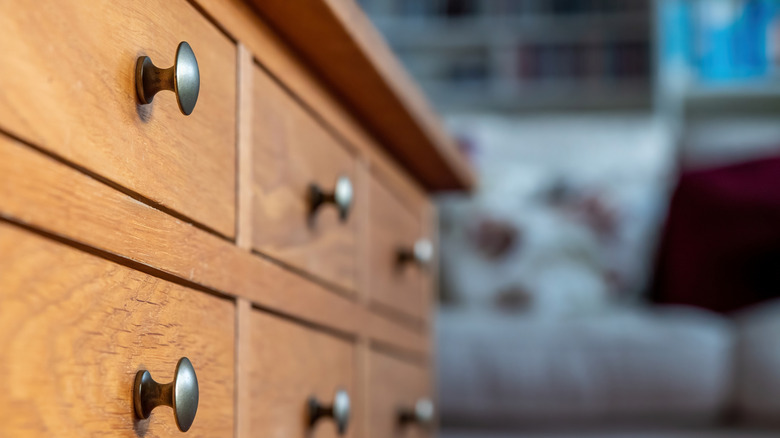 A wood dresser features metal pulls