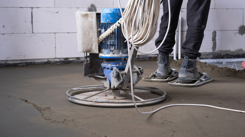 Someone creating a rammed earth floor