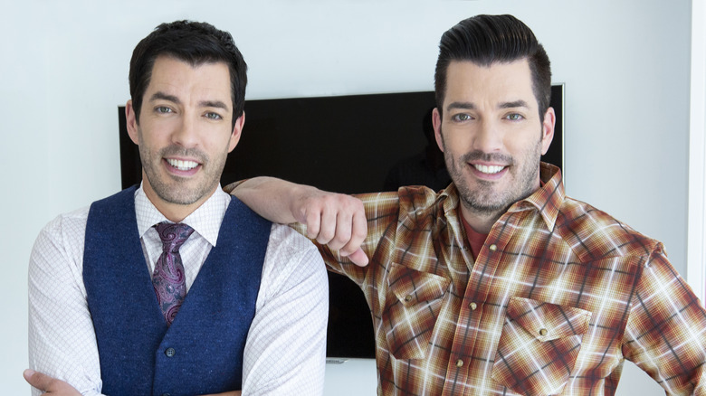 Drew and Jonathan Scott smiling while posing together