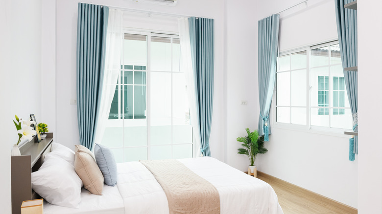 A bedroom is decorated with blue curtains