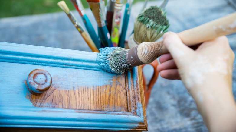 person painting furniture