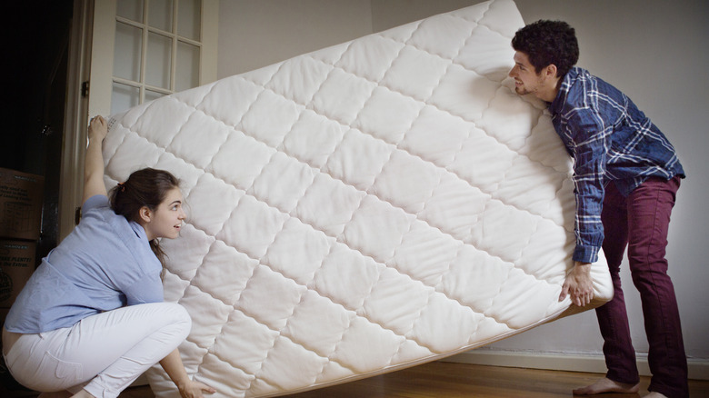 couple carrying mattress