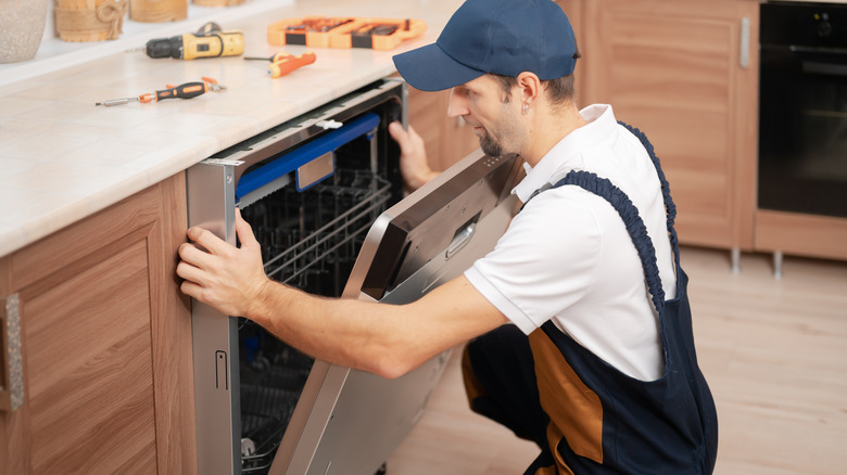 plumber installing dishwasher