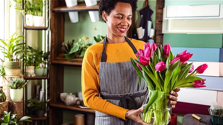 Person smiling at tulip vase