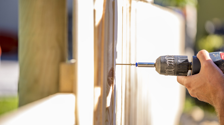 person building fence in garden