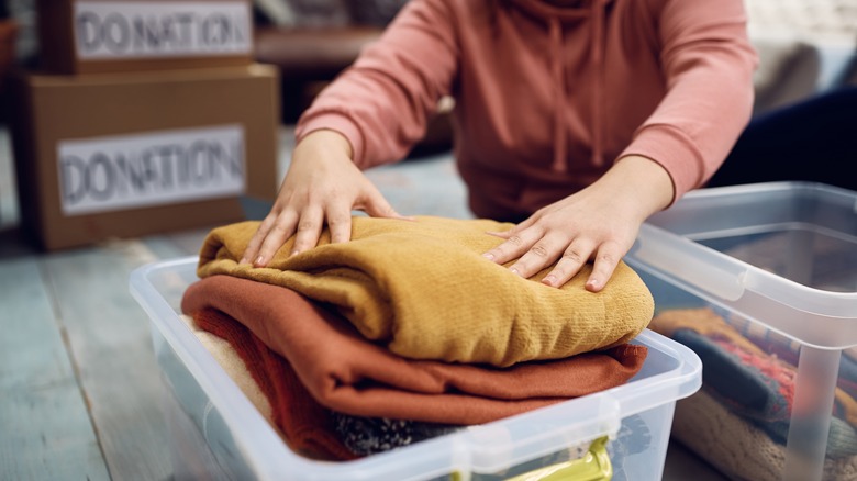 woman putting clothes in bin