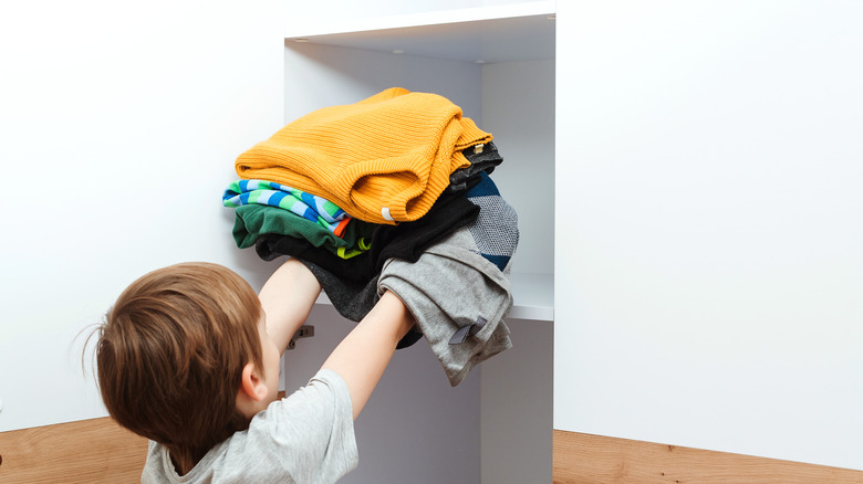 boy putting away clothes