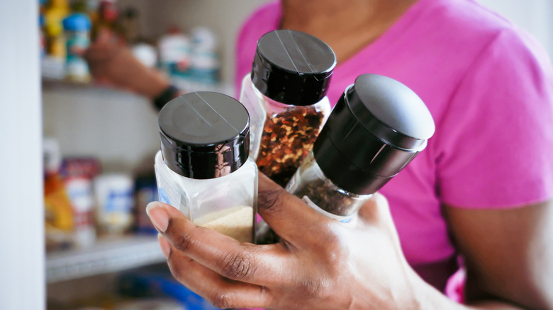 woman grabbing jars from shelves