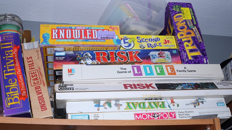 cluttered board games stored on the top shelf