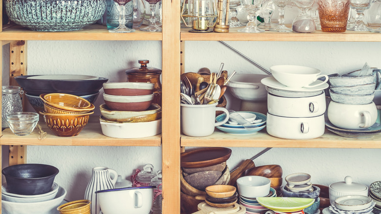 Cluttered kitchen shelves with dishes and cookware