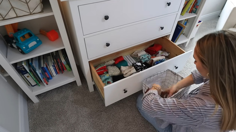 Woman organizing dresser drawer with Dollar Tree fabric bin