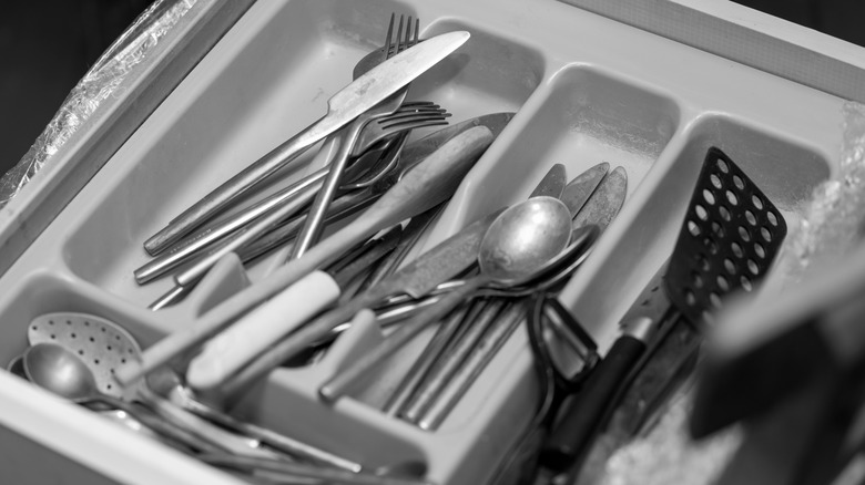 Silverware scattered throughout messy utensil organizer