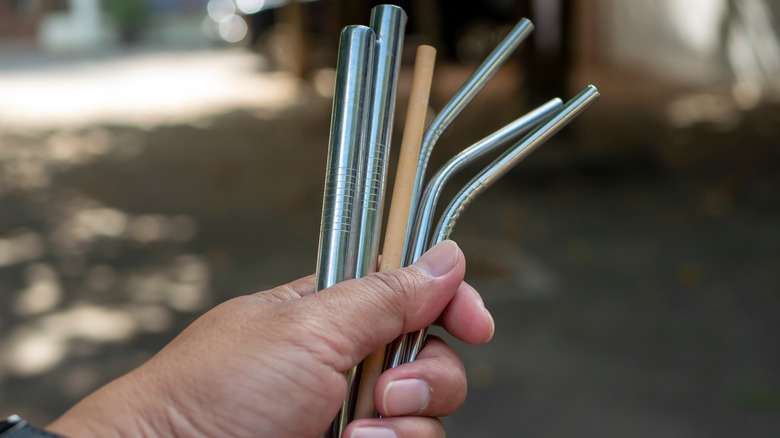 Hand holds several reusable straws