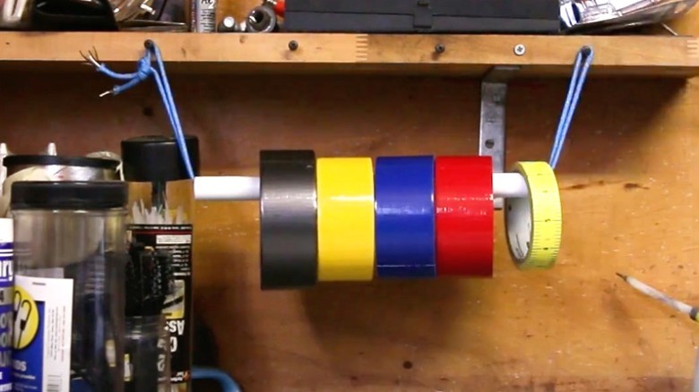 colorful tape rolls hanging on PVC rod attached to garage shelf