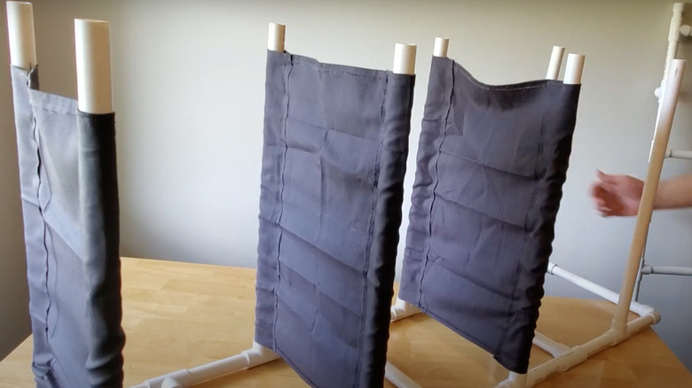 Someone building a shelf with PVC pipes and fabric