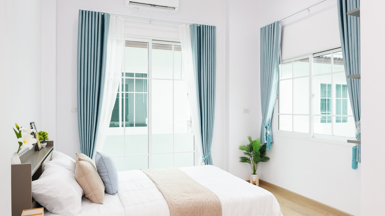 Blue and white modern curtains layered in a bedroom