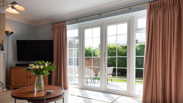 Pink curtains hanging on a gold curtain rod in a living room