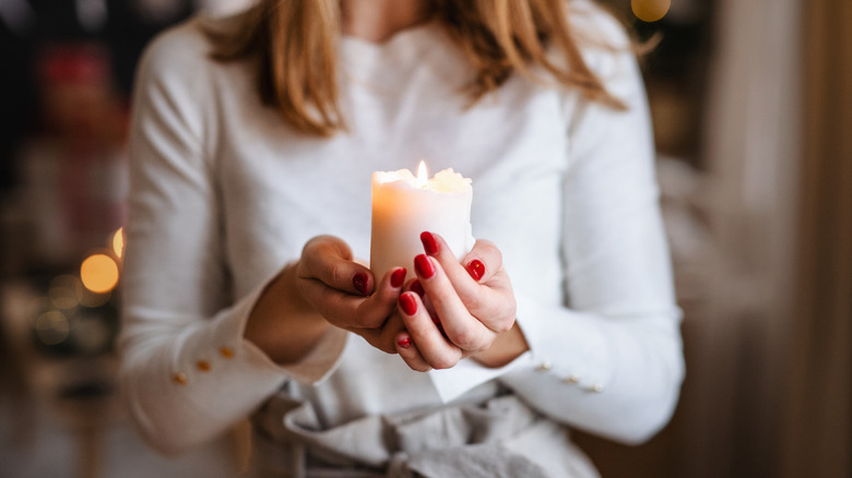 Someone holding a white candle